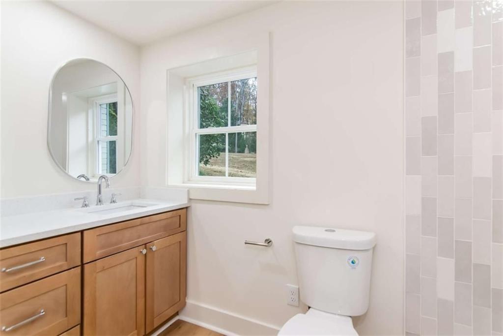 4956 Mountclaire Road Stone Mountain, GA 30087 - Photo 56 of 61 a bathroom with a toilet a sink and mirror