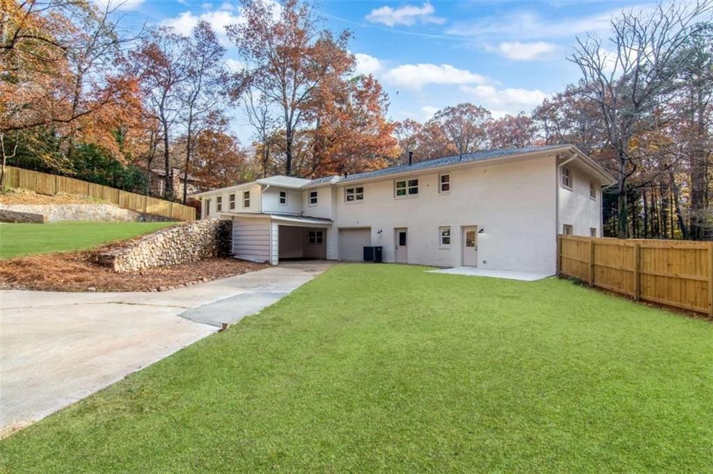 4956 Mountclaire Road Stone Mountain, GA 30087 - Photo 60 of 61 a view of a white house in front of a big yard with large tree
