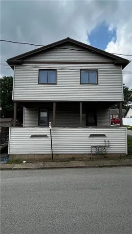 a front view of a house with a road