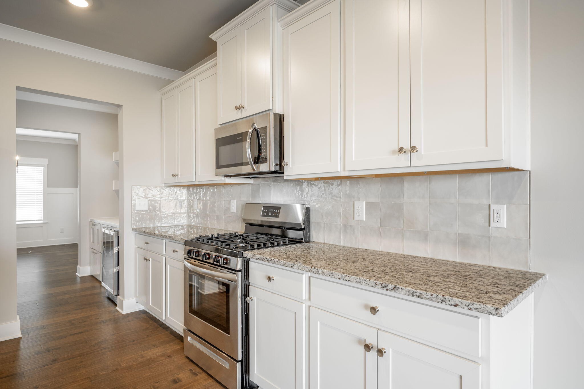 7401 McDaniel Lane Ooltewah, TN 37363 - Photo 7 of 44 a kitchen with granite countertop white cabinets and stainless steel appliances