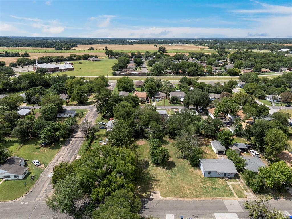 an aerial view of residential houses with outdoor space and trees