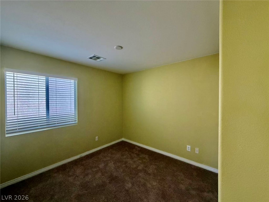 7326 Dicentra Road Las Vegas, NV 89113 - Photo 11 of 18 Plush carpeting and a wide window with blinds define this versatile secondary bedroom space.