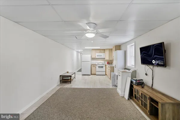 a view of a livingroom with furniture flat screen tv wooden floor and a ceiling fan