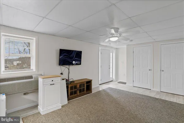 a living room with furniture a flat screen tv and kitchen view
