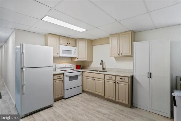 a kitchen with a white refrigerator a sink and cabinets