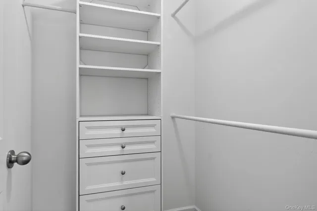 a view of walk in closet with empty racks