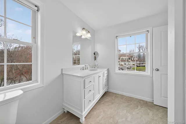 a bathroom with a double vanity sink and a window