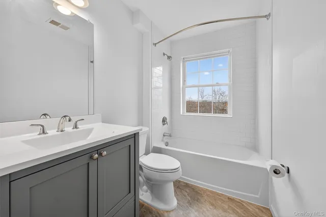 a bathroom with a toilet a sink a mirror and a bathtub