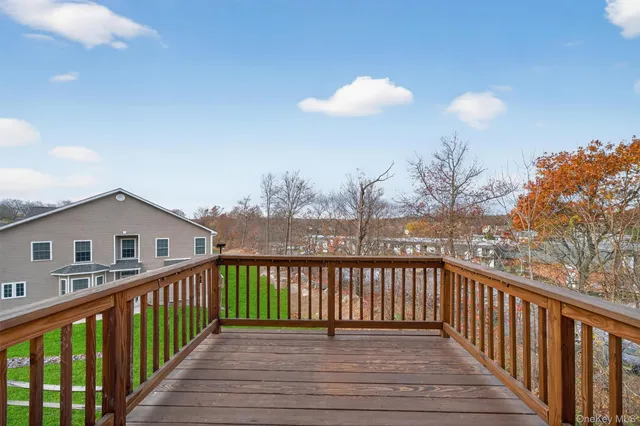 a view of a house with wooden deck and a large window