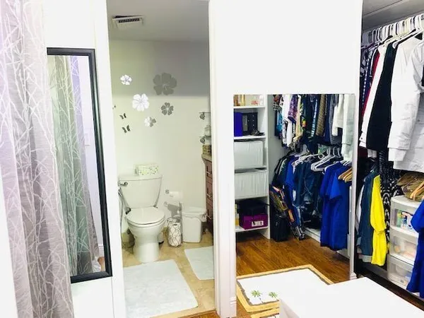 a view of walk in closet with clothes and shoes