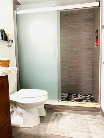 a bathroom with a toilet and a shower