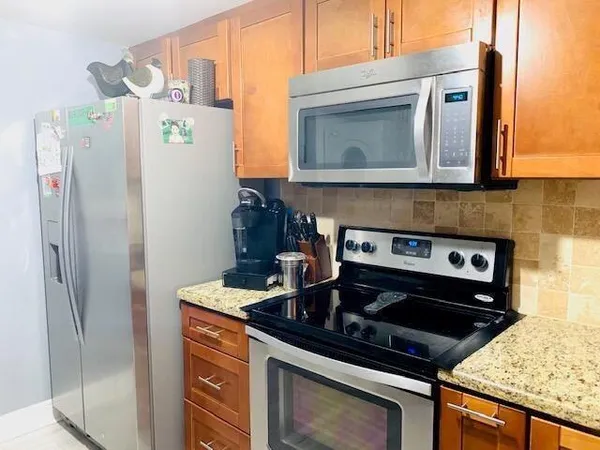 a kitchen with stainless steel appliances granite countertop a stove and a refrigerator