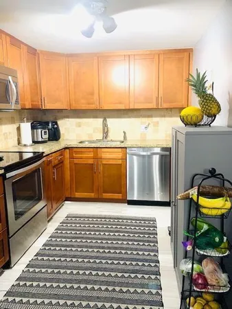 a kitchen with stainless steel appliances granite countertop a stove a sink and a microwave
