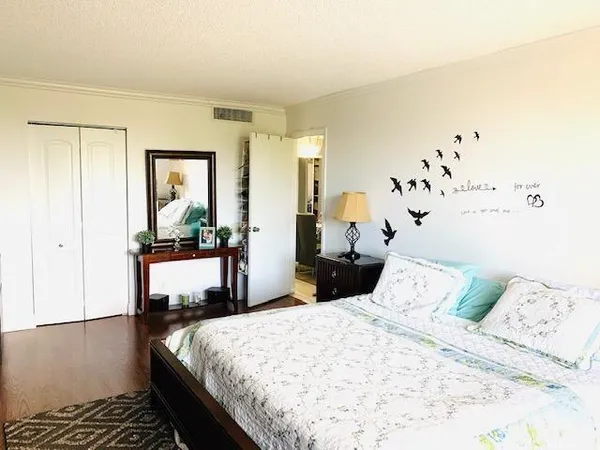 a bedroom with a large bed and wooden floor
