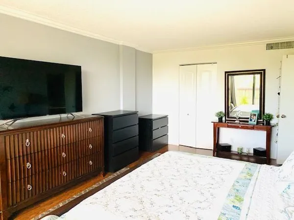 a bedroom with a bed and a flat screen tv