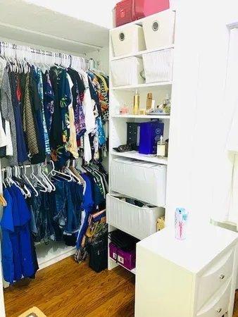 a view of walk in closet with clothes and shoes