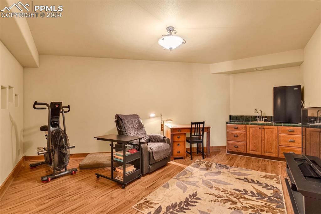 1747 Newton Road Pueblo, CO 81005 - Photo 27 of 50 a view of a workspace with furniture and a wooden floor
