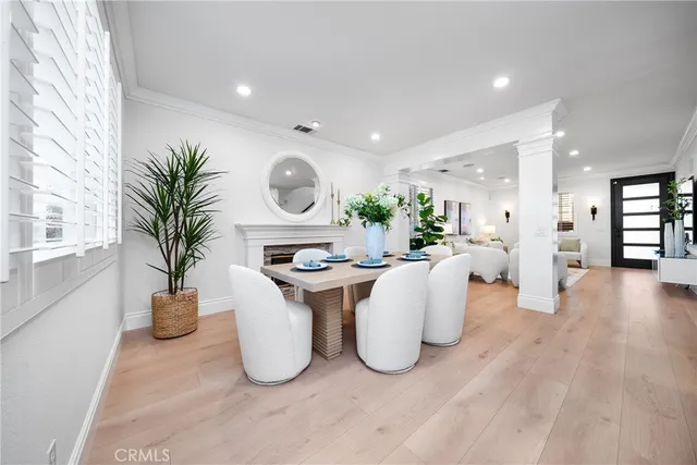 a living room with furniture a potted plant and a large window