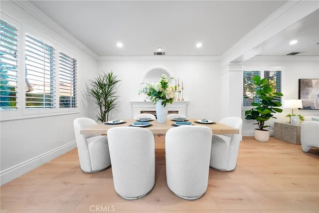 a dining room with furniture a potted plant and kitchen view