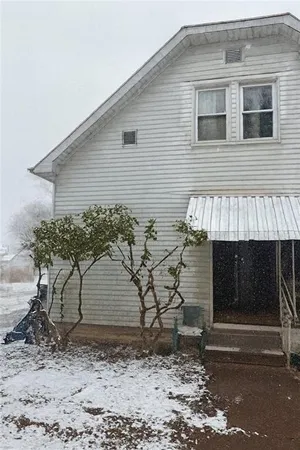 a brick house with a small yard and large tree