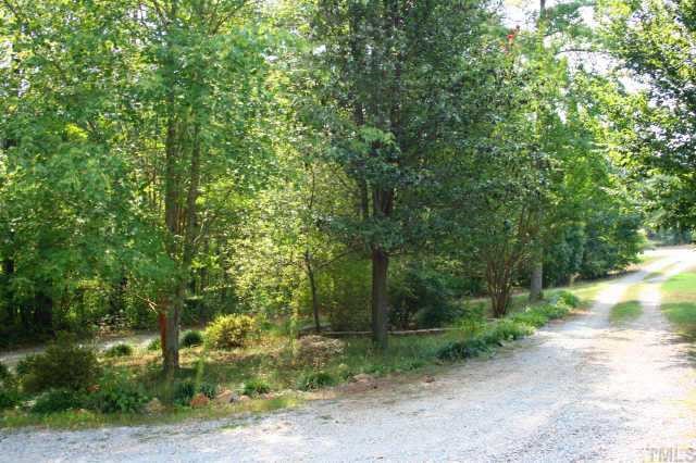 4 Orion Circle Rougemont, NC 27572 - Photo 5 of 8 a view of a yard with plants and trees beside of it
