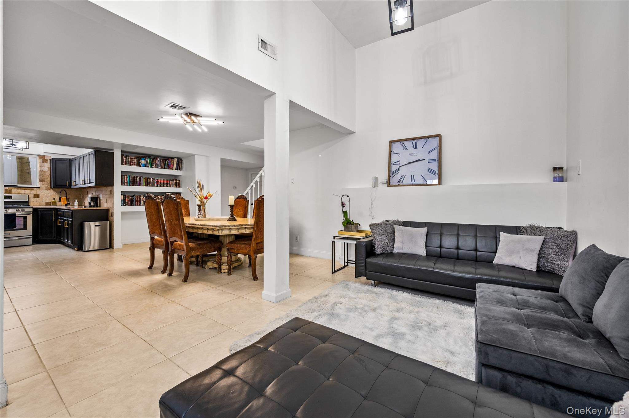 1016 Westwood Road Woodmere, NY 11598 - Photo 12 of 23 a living room with furniture and a dining table with kitchen view