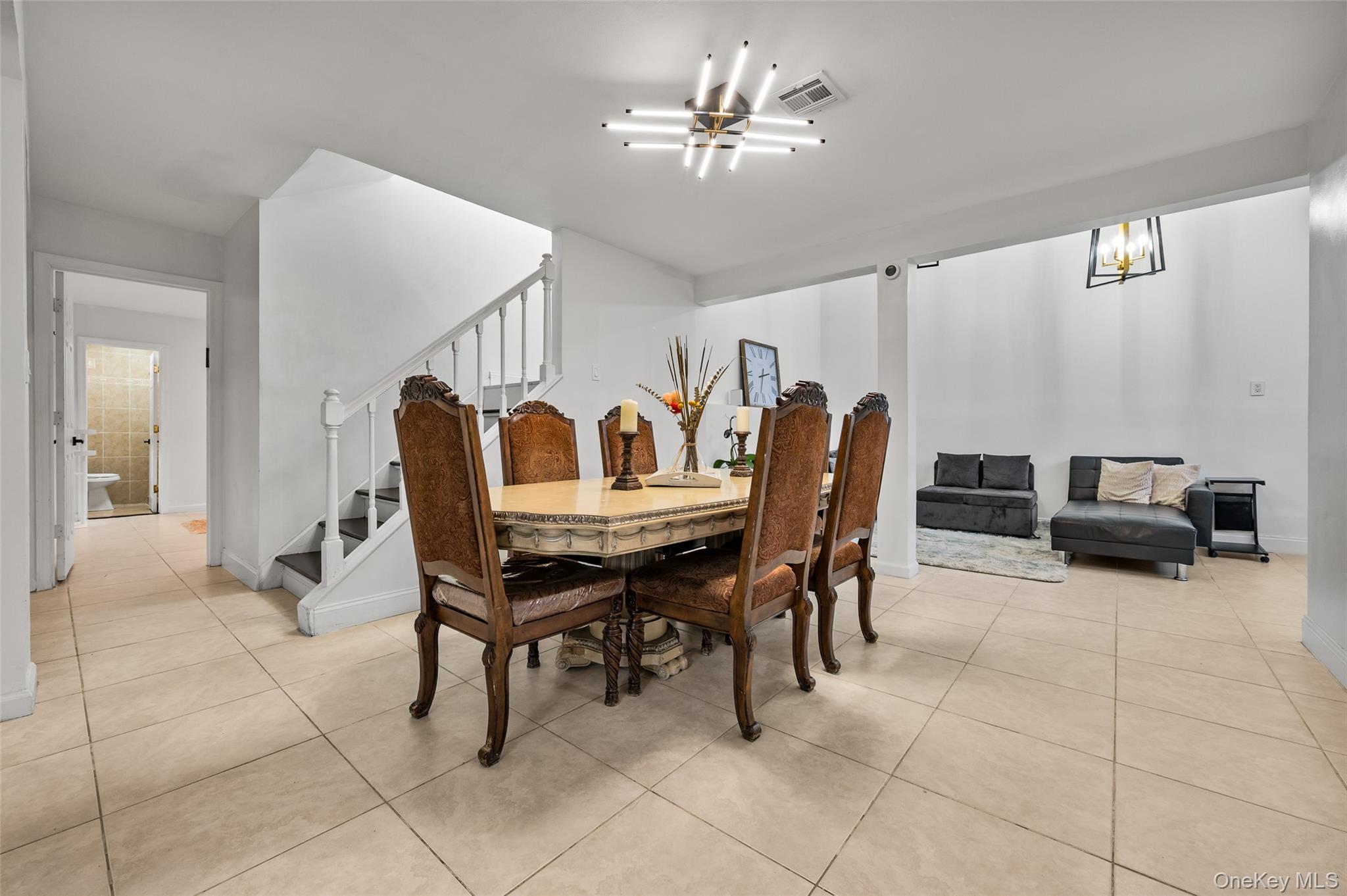 1016 Westwood Road Woodmere, NY 11598 - Photo 13 of 23 a dining room with furniture and a chandelier