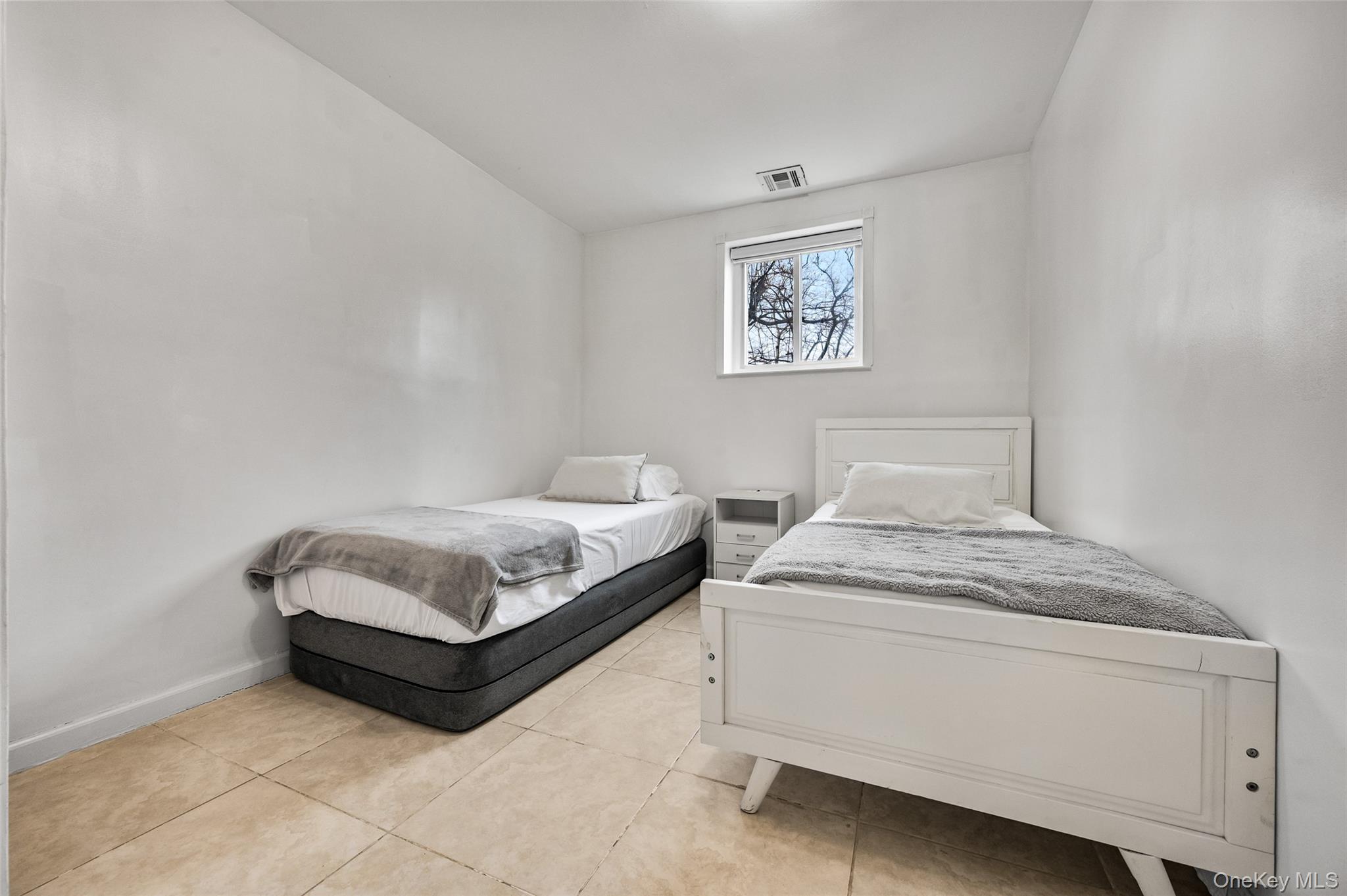 1016 Westwood Road Woodmere, NY 11598 - Photo 20 of 23 a bedroom with a bed and a lamp on table