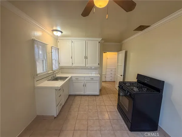 a kitchen with a stove sink and cabinets