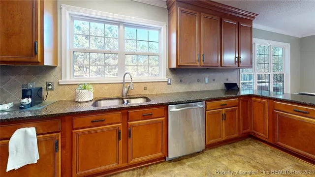 a kitchen with stainless steel appliances granite countertop wooden cabinets a sink and dishwasher with wooden floor