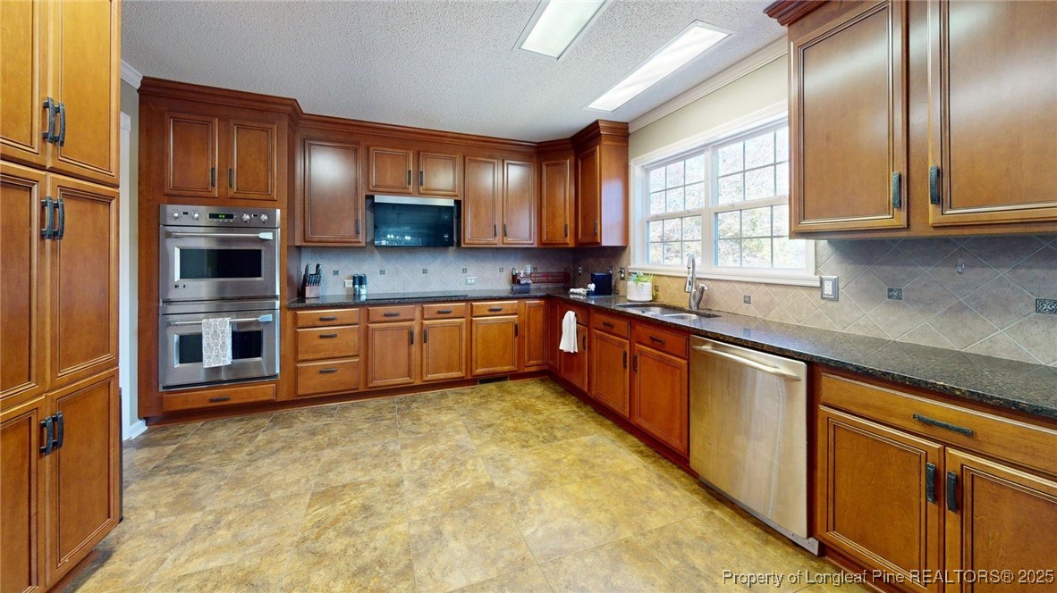 120 Mockingbird Lane Spring Lake, NC 28390 - Photo 10 of 23 a kitchen with stainless steel appliances granite countertop a sink a stove and cabinets