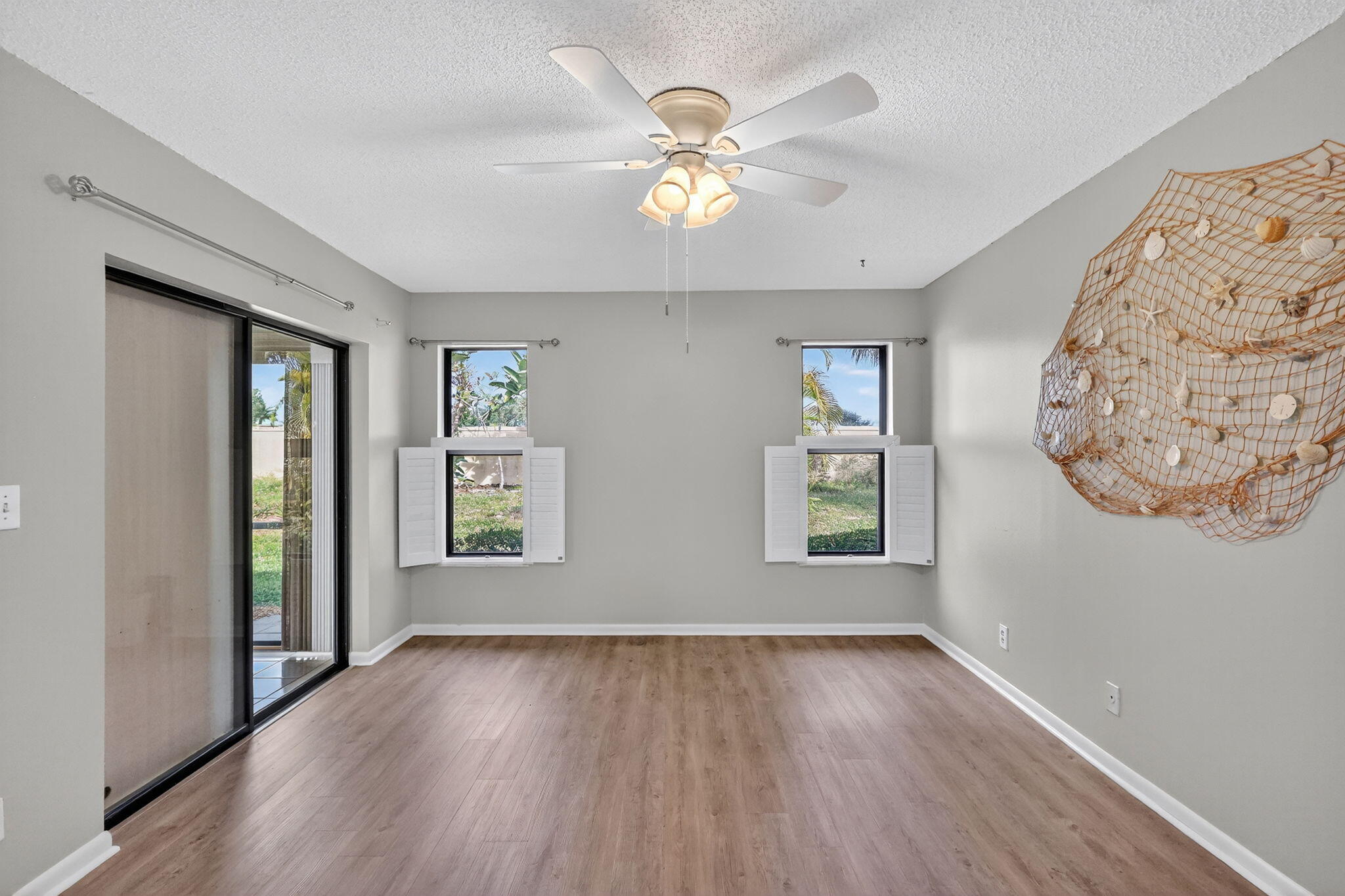 7643 Southeast Sugar Sand Circle Hobe Sound, FL 33455 - Photo 10 of 44 wooden floor in an empty room with a window