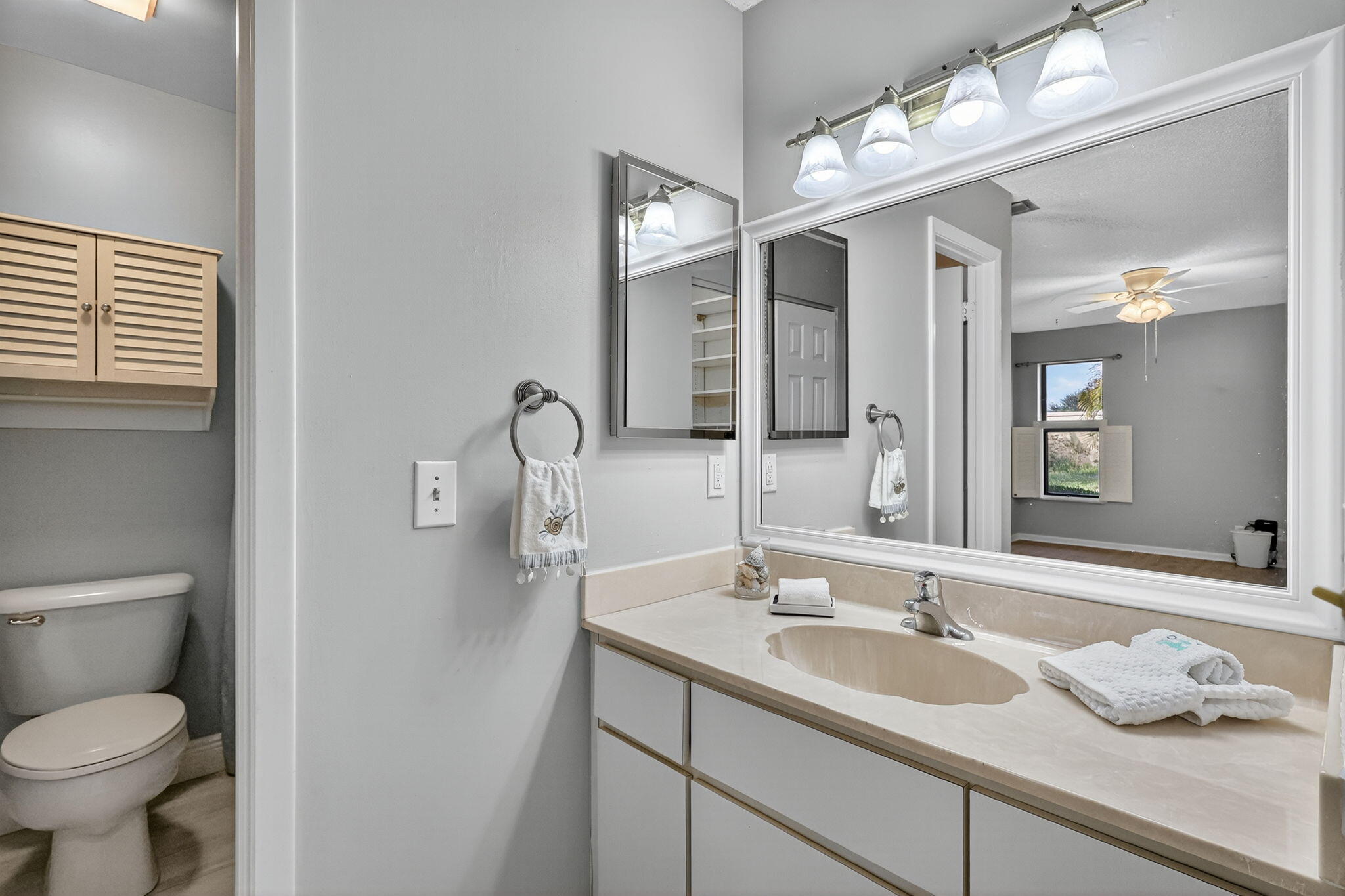 7643 Southeast Sugar Sand Circle Hobe Sound, FL 33455 - Photo 13 of 44 a bathroom with a granite countertop sink toilet and mirror