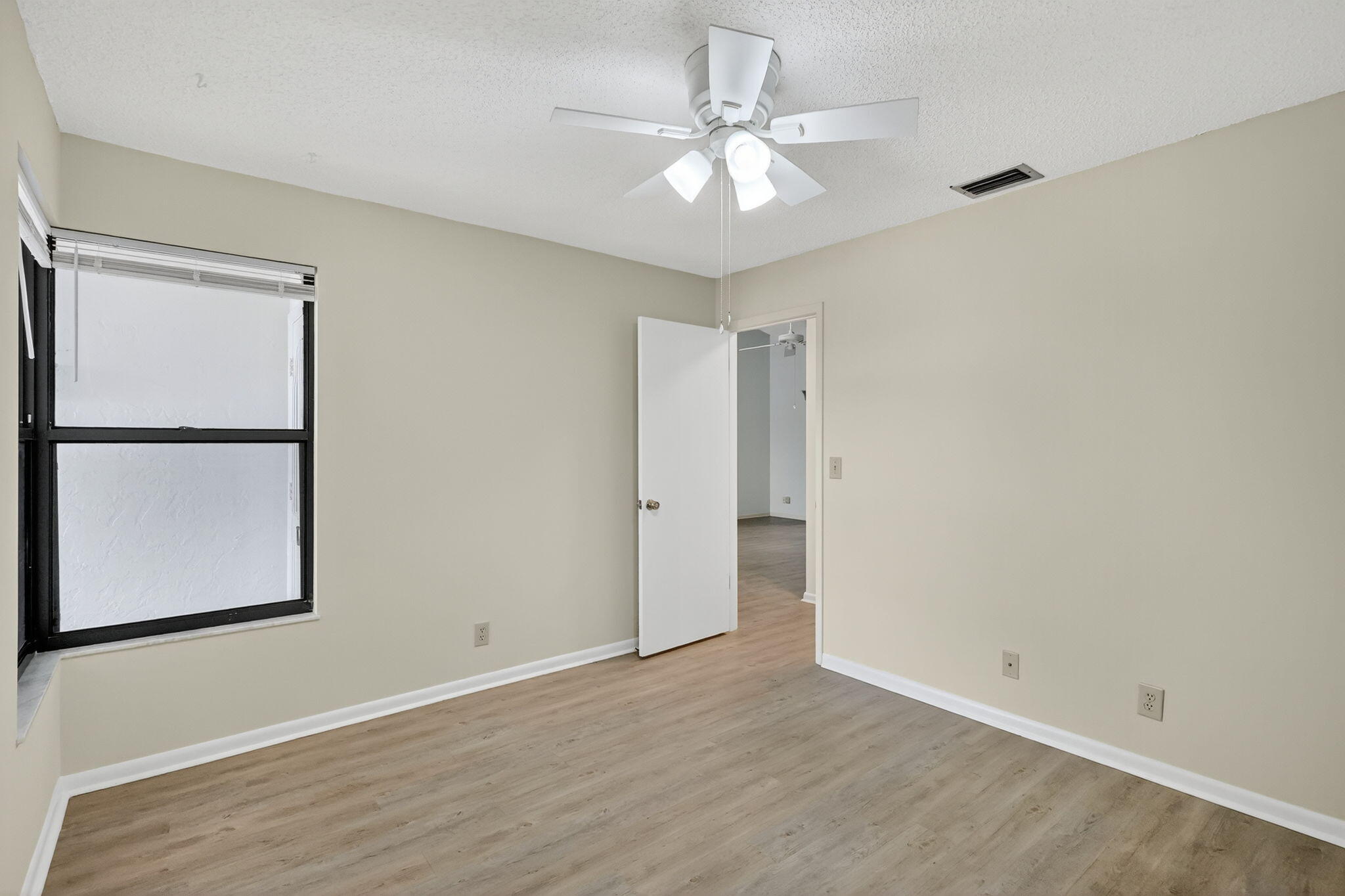 7643 Southeast Sugar Sand Circle Hobe Sound, FL 33455 - Photo 17 of 44 wooden floor in an empty room with a window