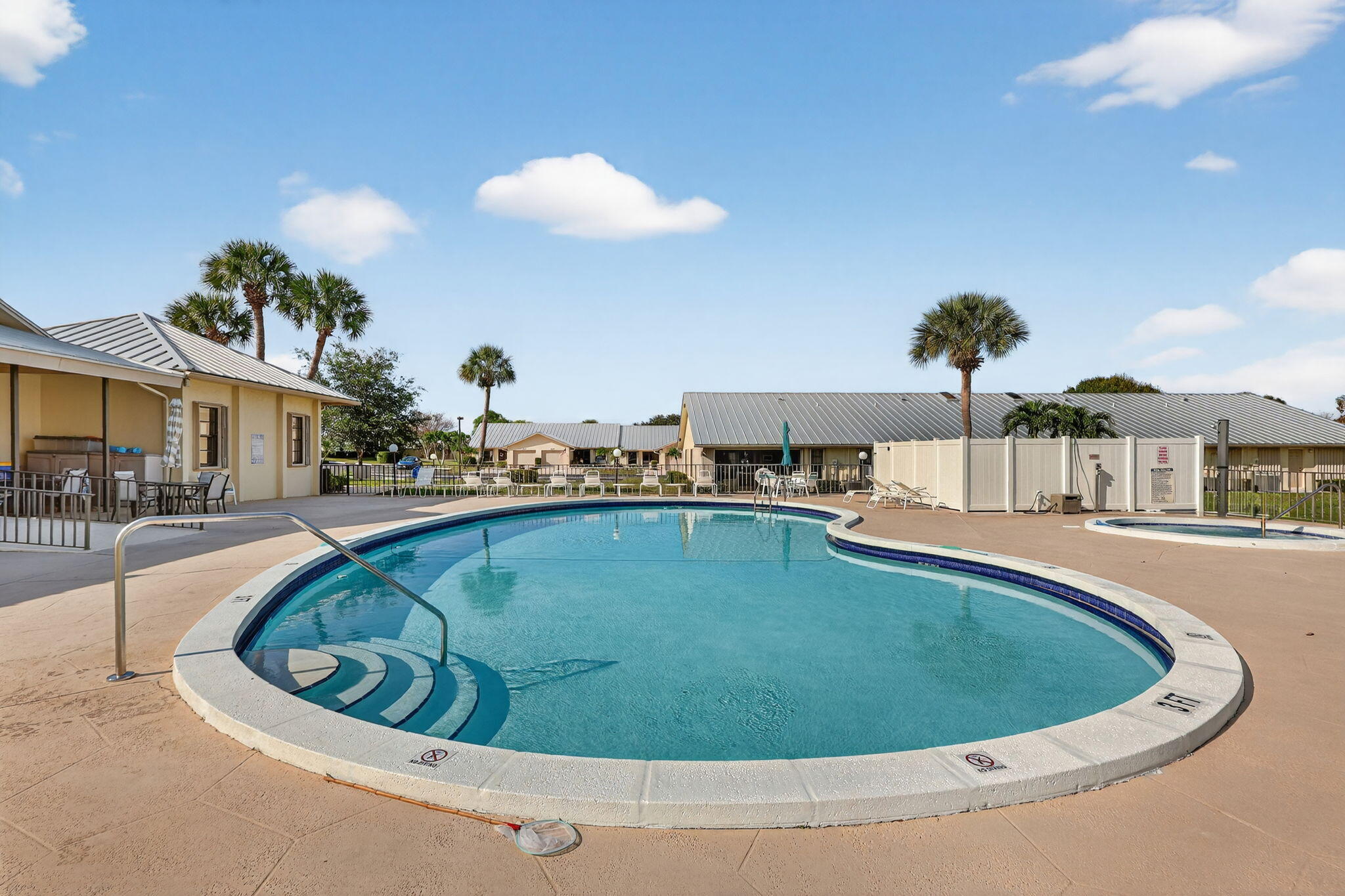 7643 Southeast Sugar Sand Circle Hobe Sound, FL 33455 - Photo 26 of 44 a view of a swimming pool with a table and chairs