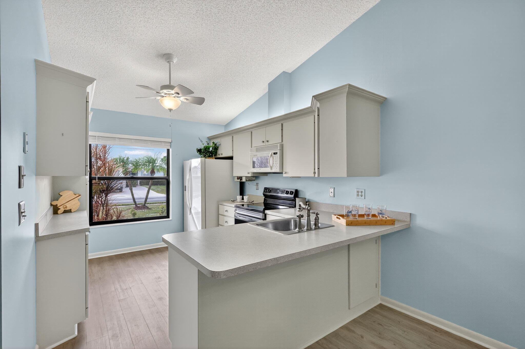 7643 Southeast Sugar Sand Circle Hobe Sound, FL 33455 - Photo 3 of 44 a kitchen with stainless steel appliances a sink a window and cabinets