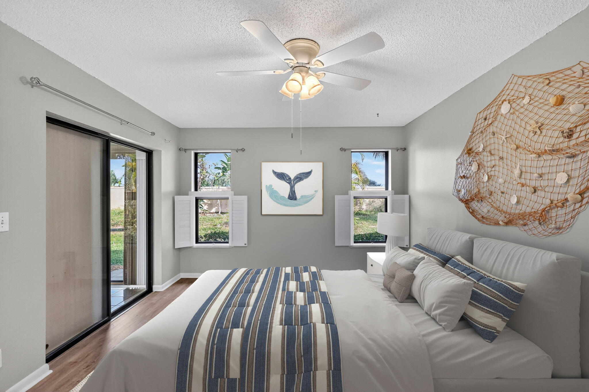 7643 Southeast Sugar Sand Circle Hobe Sound, FL 33455 - Photo 9 of 44 a bedroom with a large bed and a window