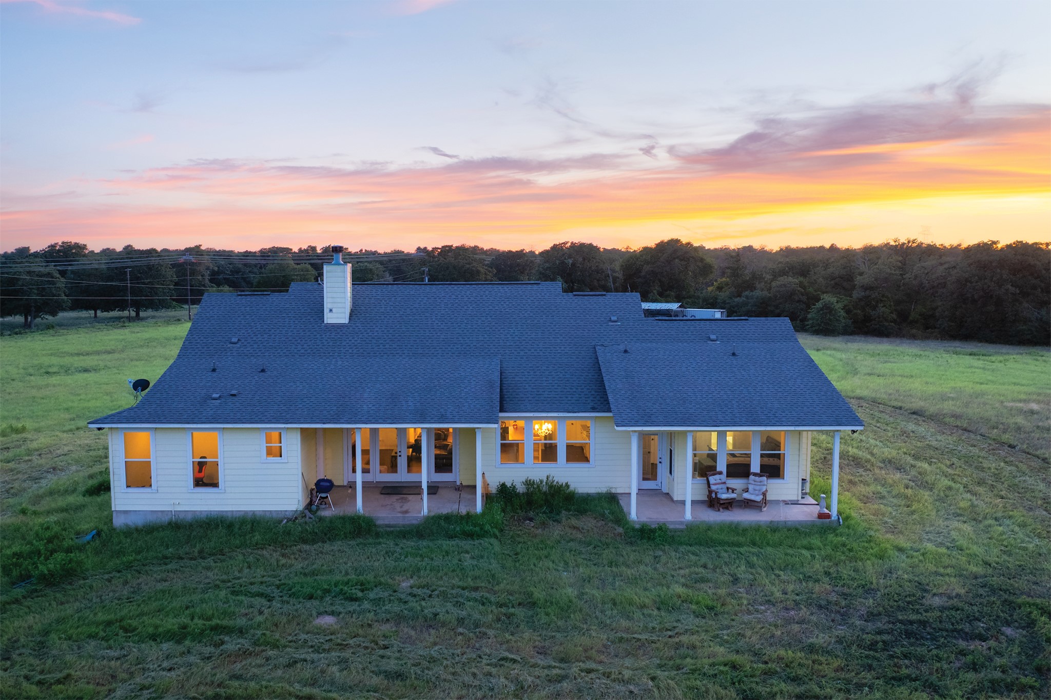 498 North County Line Road Elgin, TX 78621 - Photo 2 of 40 Back of property with a patio area, a yard, roof with shingles, and a chimney