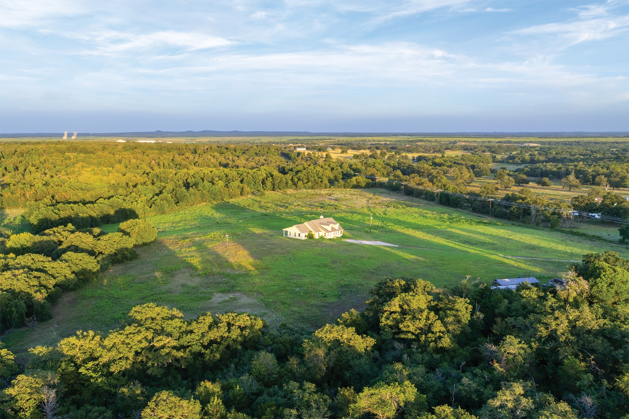498 North County Line Road Elgin, TX 78621 - Photo 25 of 40 Aerial view of property and surrounding area with a heavily wooded area and rural landscape