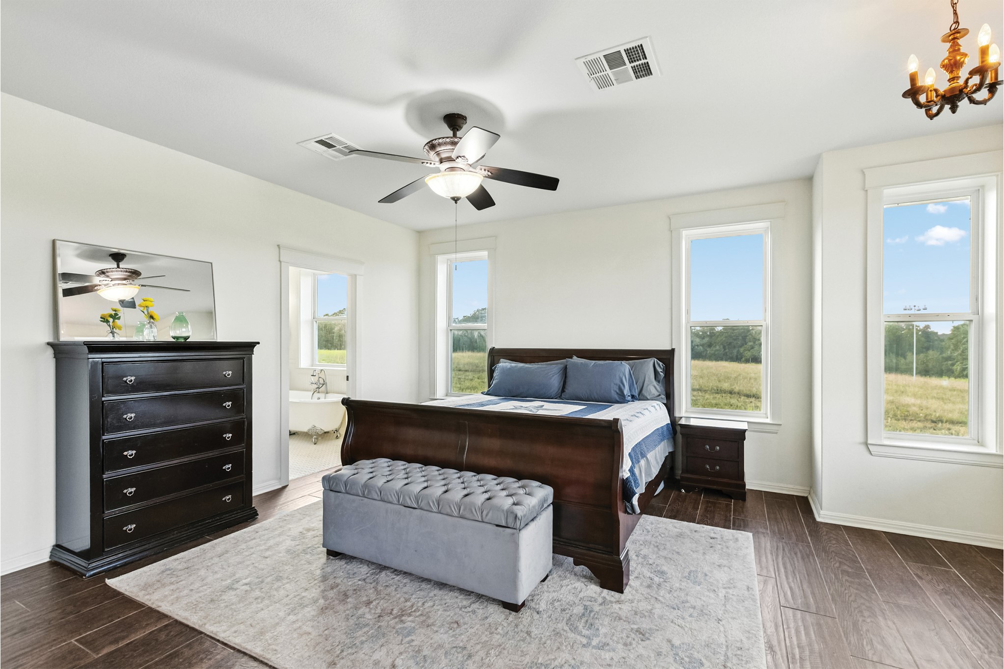 498 North County Line Road Elgin, TX 78621 - Photo 32 of 40 Bedroom with dark wood-style floors, ensuite bath, ceiling fan, and a chandelier