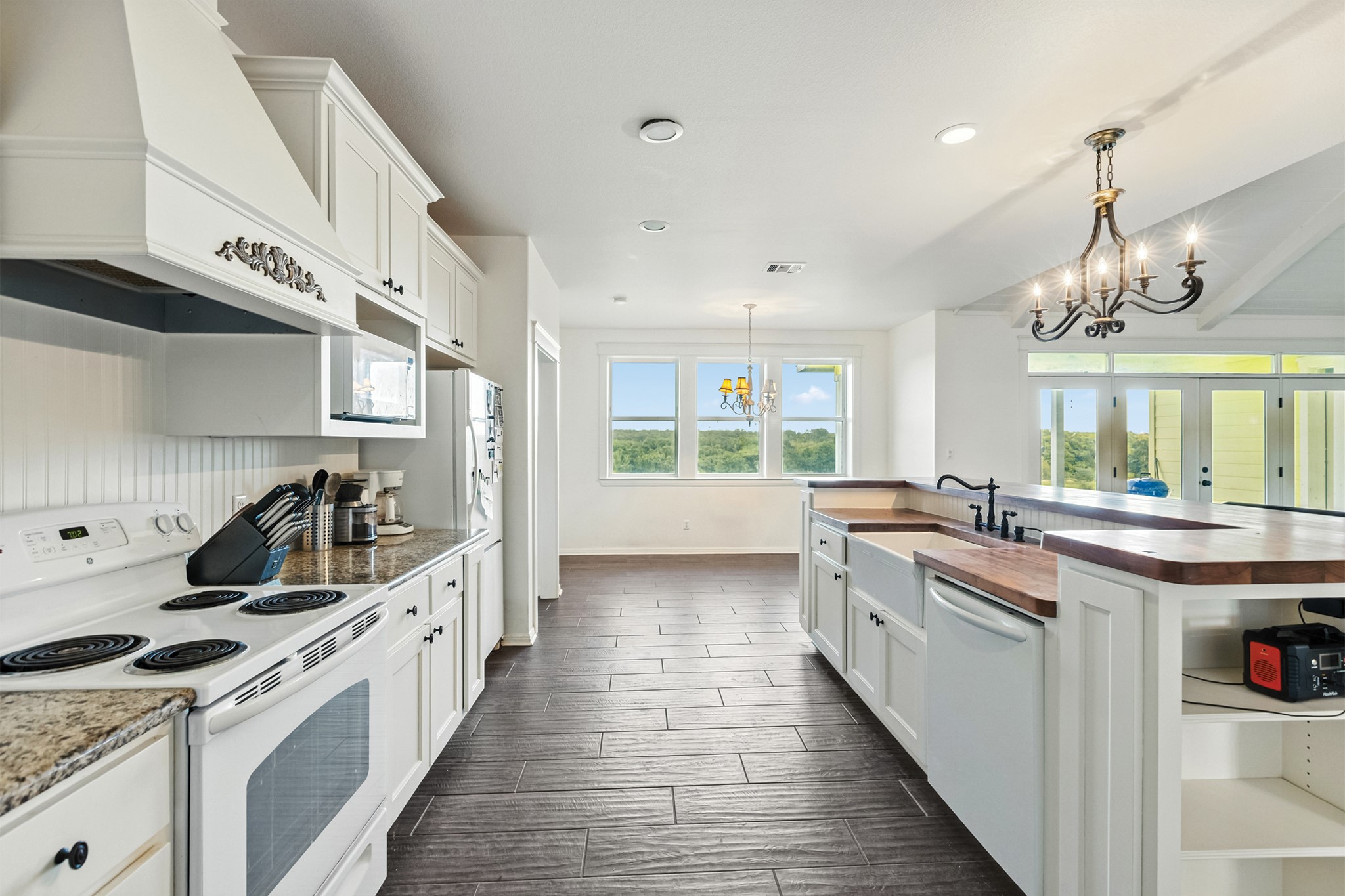 498 North County Line Road Elgin, TX 78621 - Photo 33 of 40 Kitchen with white appliances, white cabinets, custom range hood, hanging light fixtures, and recessed lighting