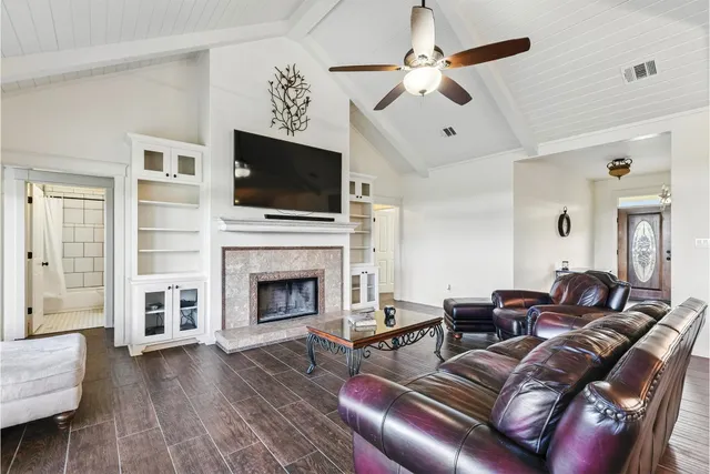 a living room with furniture a flat screen tv and a fireplace