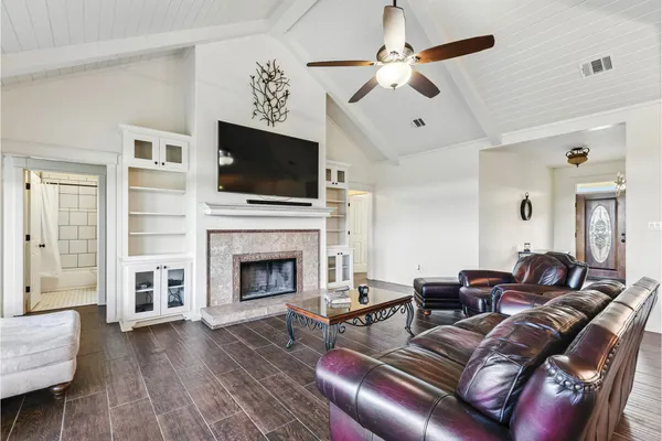a living room with furniture a flat screen tv and a fireplace