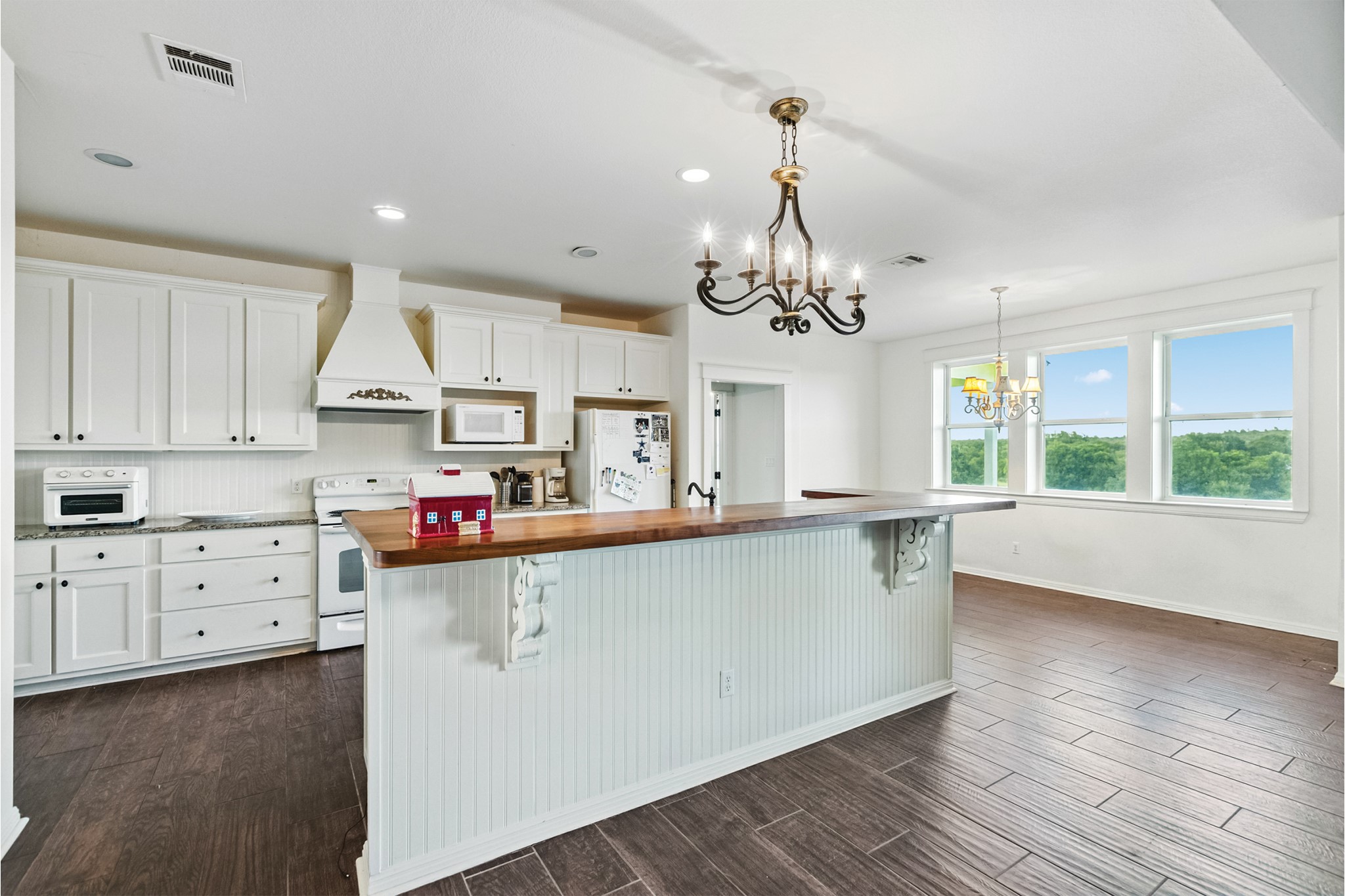 498 North County Line Road Elgin, TX 78621 - Photo 6 of 40 Kitchen with butcher block countertops, a breakfast bar area, white cabinetry, a chandelier, and recessed lighting