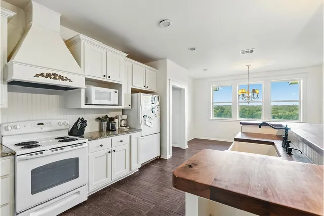 a kitchen with stainless steel appliances a stove a sink and white cabinets