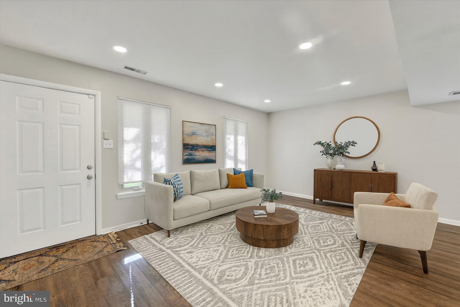 a living room with furniture and a wooden floor