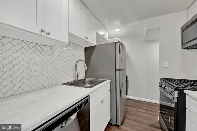 a kitchen with stainless steel appliances a sink and a refrigerator