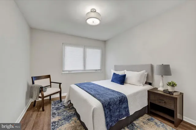 a bedroom with a bed and a lamp on dresser