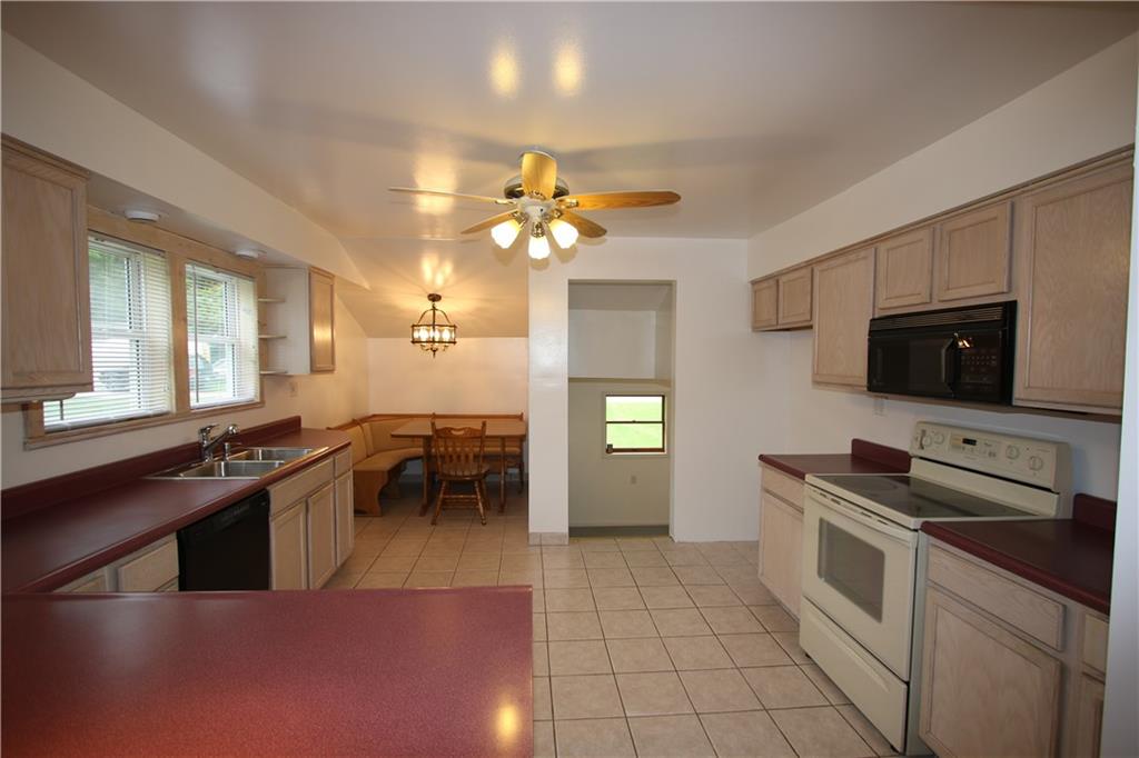 Beautifully Updated Eat-in Kitchen w/ Ceramic Tile Floors, plenty of Wood Cabinets & Convenient Dining area featuring Corner Bench Seats offering storage & Table include in sale