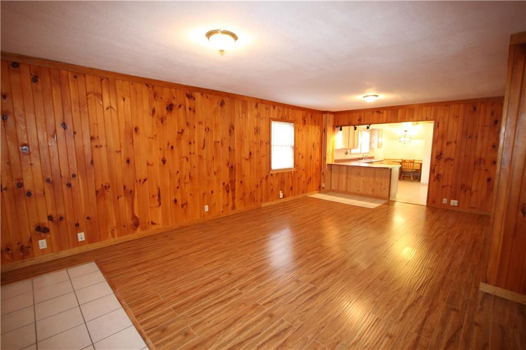 Massive Living Room / Dining Room combo offering Knotty Pine Paneling